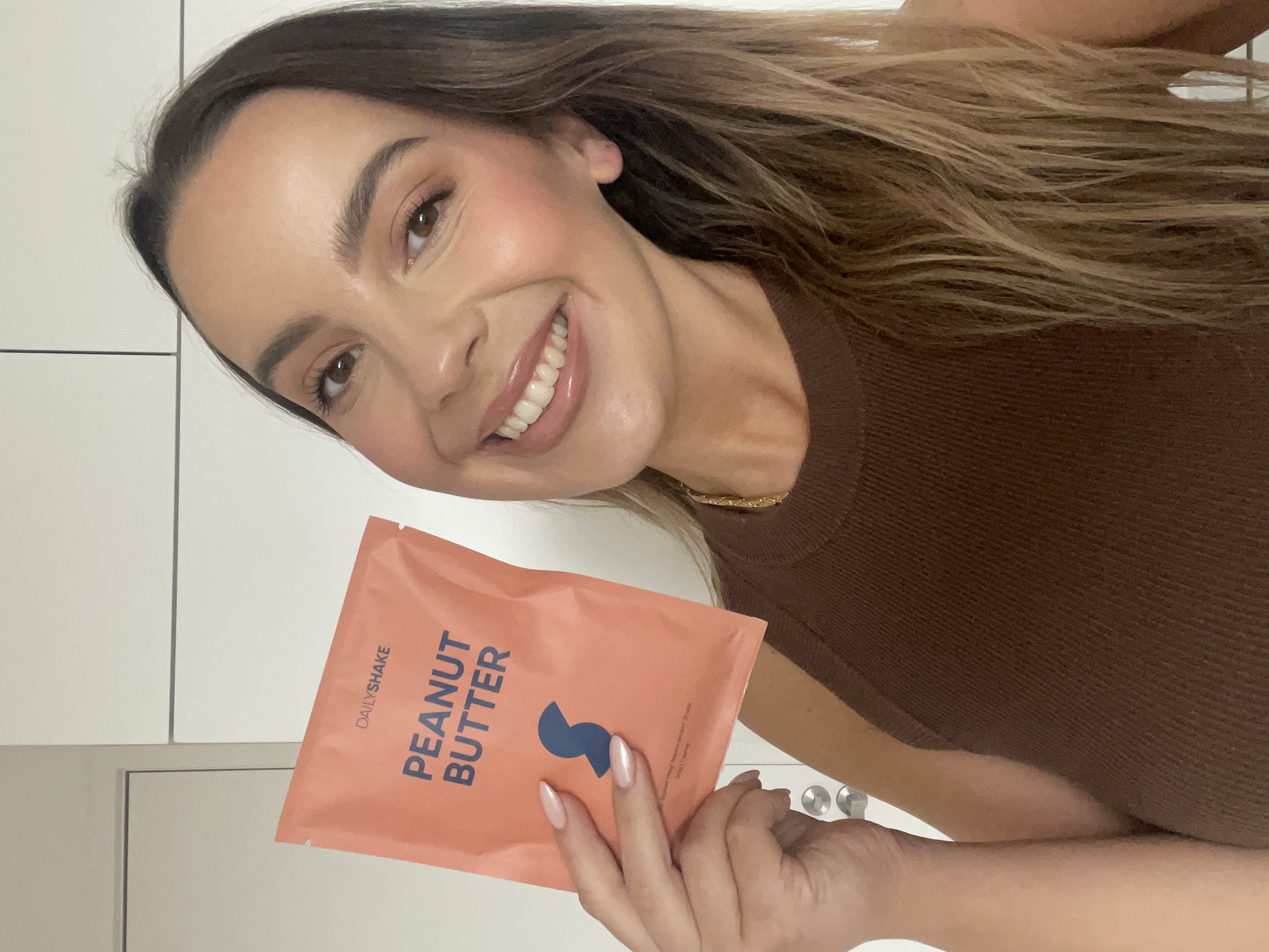 Beth holding a Daily Shake Peanut Butter sachet