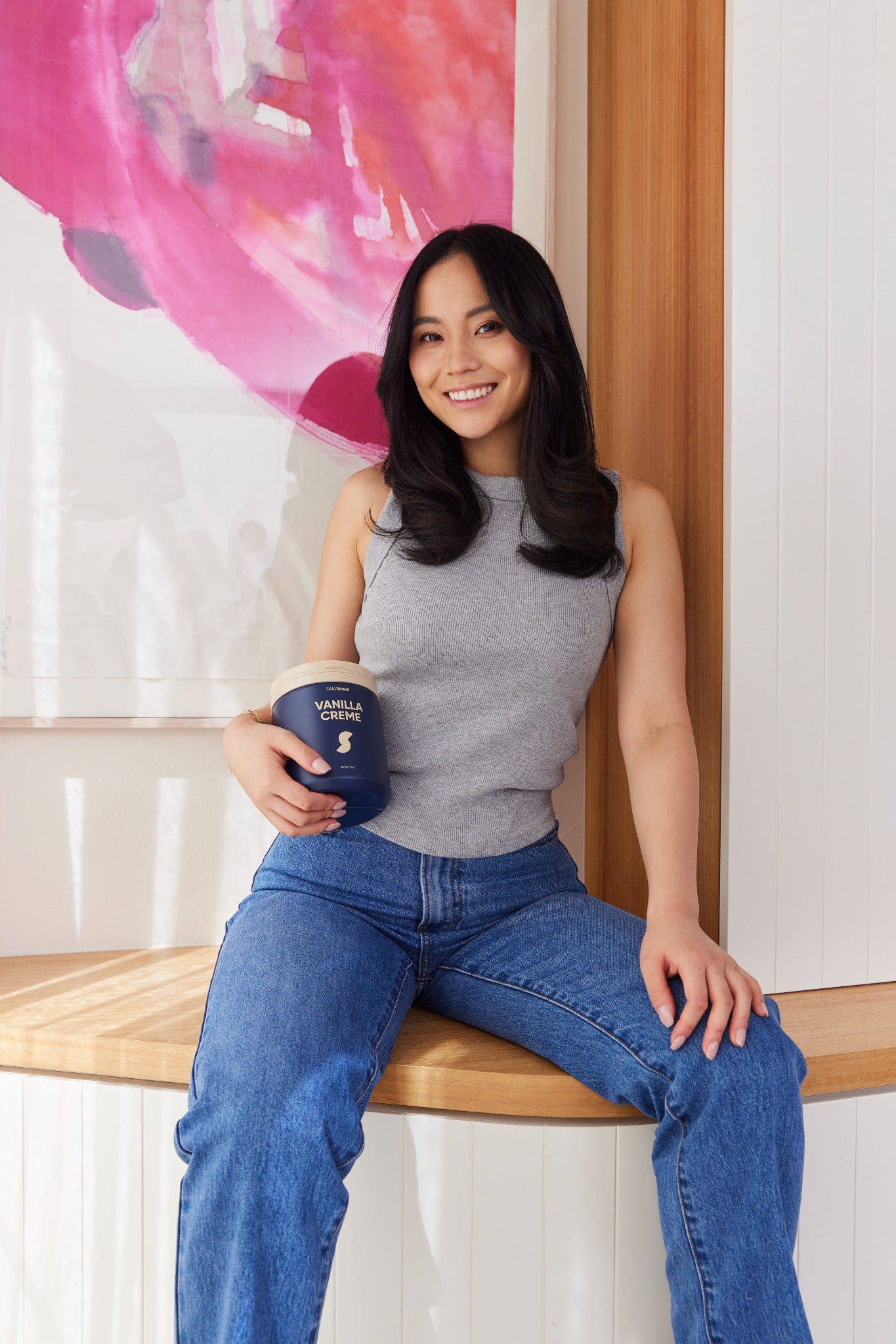 Woman holding a Vanilla Creme Daily Shake jar